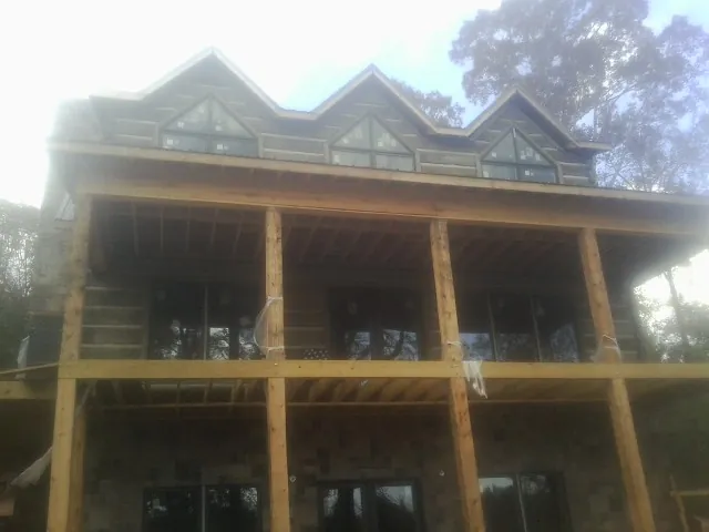 Dormers and porch framing on a large log home under construction — Roof Coating work by our crew in Church Creek