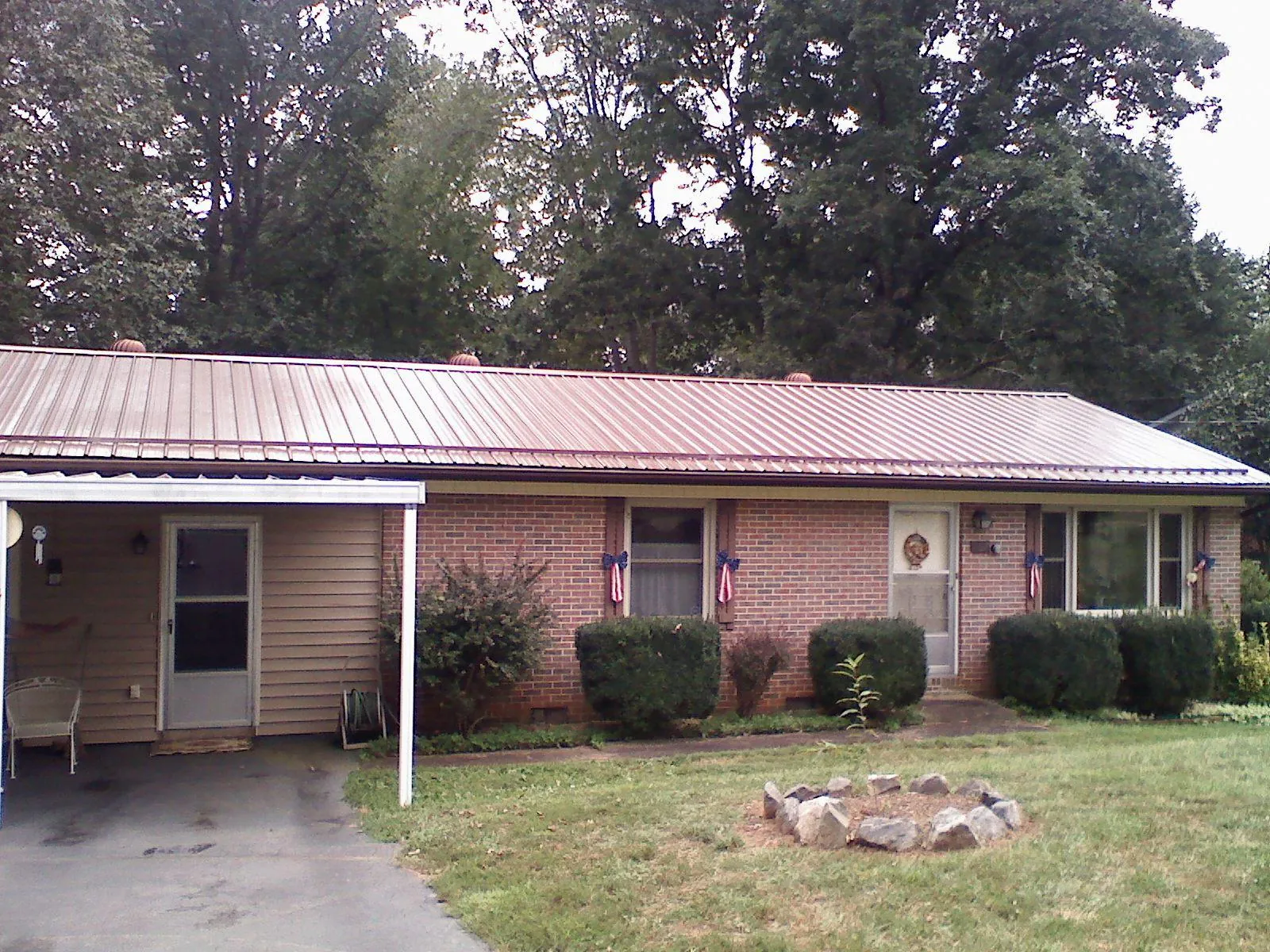 Bronze metal roof and carport on a brick ranch home — Roof Repair work by our crew in Church Creek